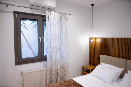 1 dormitorio con cama y ventana en Kefaloviso Luxury Apartment 2, en Nafpaktos