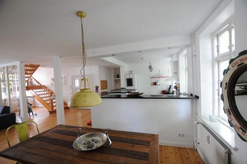 een keuken en een woonkamer met een houten tafel in een kamer bij Linde in Flensburg