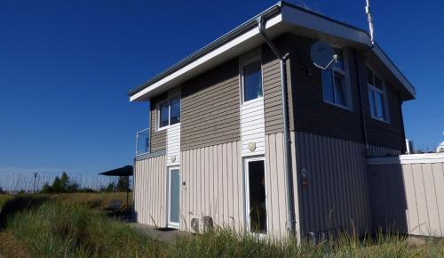 a small house with a black and white exterior at Ferienhaus Meerzeit Marina Wendtorf in Wendtorf