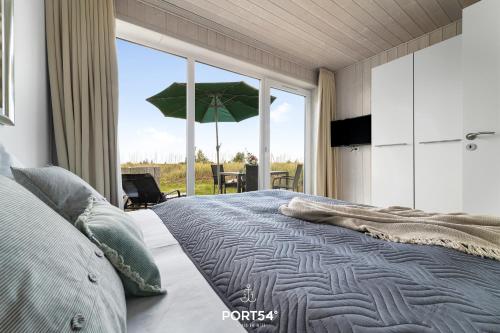a bedroom with a large bed with an umbrella at Ferienhaus Lagunenblick 23 Marina Wendtorf in Wendtorf