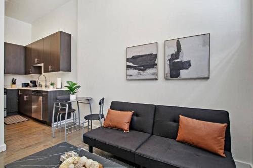 a living room with a black couch and a kitchen at 1BR Adorable Apt with In-unit Laundry - Lake 206 rep in Chicago