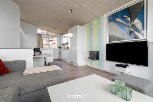 a living room with a couch and a flat screen tv at Ferienhaus Möwennest Marina Wendtorf in Wendtorf