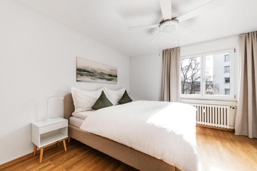 Un dormitorio blanco con una cama grande y una ventana en Familienwohnung !Gratis Parken, Free Parking!, en Kreuzlingen