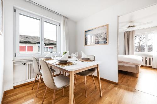 a white dining room with a table and chairs at SOHO F !Gratis Parken, Free Parking! in Kreuzlingen
