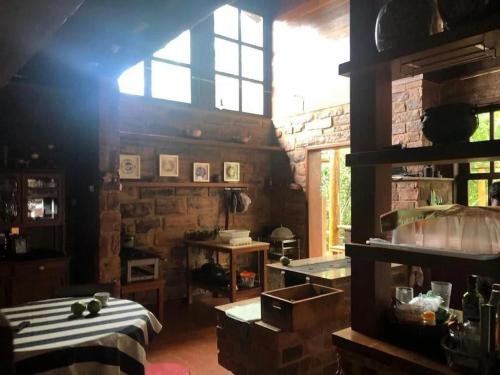 a kitchen with a room with a table and a window at Pousada Casa Fraternità, viva momentos de tranquilidade em contato com a natureza. in Andaraí