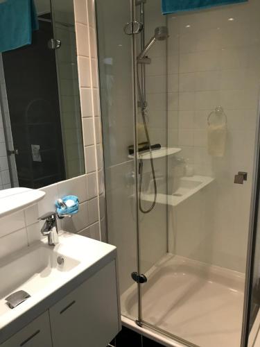a bathroom with a shower and a sink and a tub at Villa 't Haasduin in Wijk aan Zee