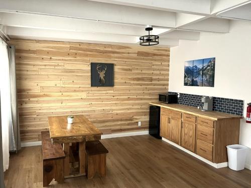 Wofford Village Studios في Wofford Heights: مطبخ بجدار خشبي وطاولة خشبية