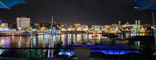 Blick auf die Stadt bei Nacht mit Booten im Wasser in der Unterkunft La Terrace in Assuan