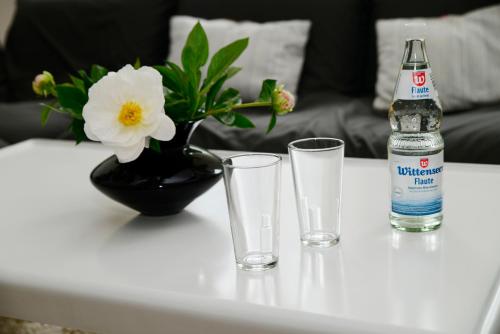 uma garrafa de água e dois copos numa mesa em Albatros em Flensburg