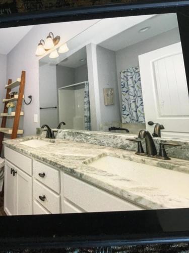 a bathroom with two sinks and a large mirror at Donna’s Sunset Meadow in Loudon