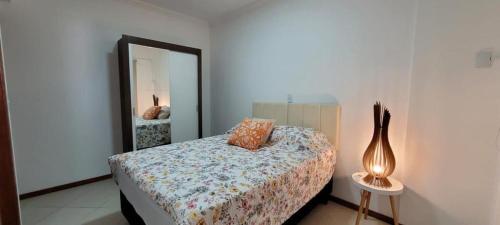 - une chambre avec un lit doté d'un miroir et d'une lampe dans l'établissement Apartamento 17 San Victor, à Bombinhas
