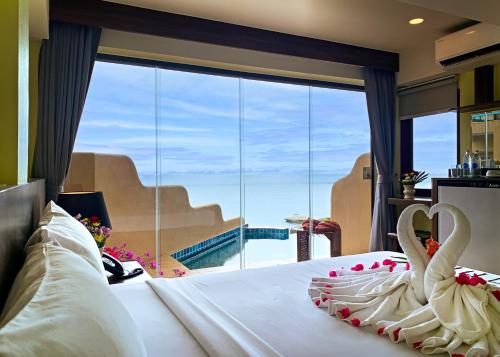 チャウエンノイビーチにあるBaan Hin Sai Resort & Spaの海の景色を望むベッドルームに白鳥2羽