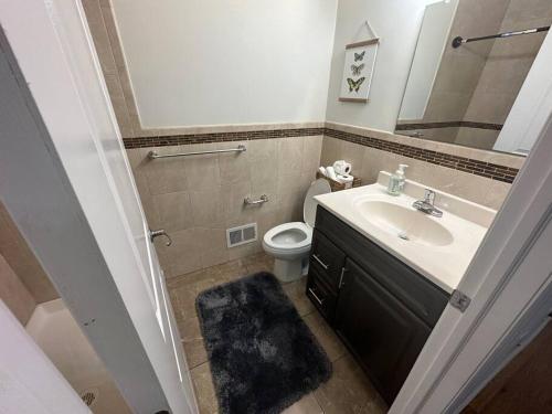 a bathroom with a sink and a toilet and a mirror at Urban Oasis 3 Kings bed 3Mins from EWR-NYC Downtow in Newark