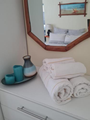 uma casa de banho com toalhas e um espelho numa cómoda em 20 Almond Rd em Kingsborough