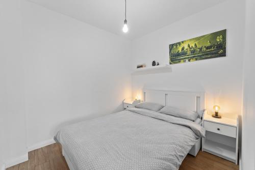 een witte slaapkamer met een bed en een bureau bij Ametist Apartment with parking in Floreşti
