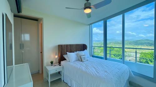 a bedroom with a bed and a large window at 10G Perfect 2 Bedroom with Ocean and Jungle Views in ArraijÃ¡n