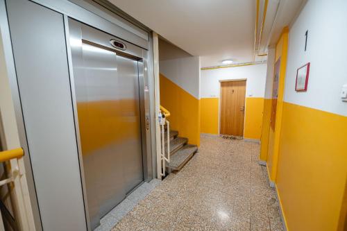 a hallway with a glass door and yellow walls at Apartma Golob in Maribor