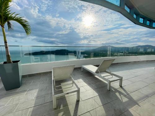 a balcony with two chairs and a bench on a building at 10G Perfect 2 Bedroom with Ocean and Jungle Views in ArraijÃ¡n