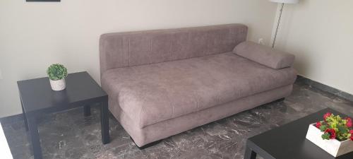 a brown couch in a living room with two tables at Di fronte alla fortezza in Nafplio