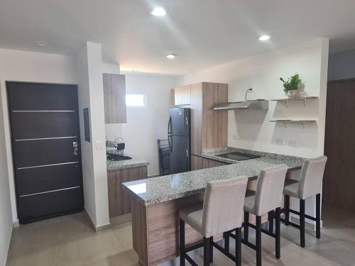 Una cocina con mesa y sillas y un refrigerador. en Departamento Vacacional en Mazatlán, en Mazatlán