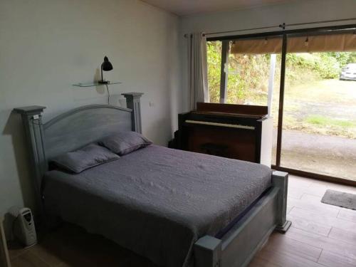 a bedroom with a bed and a large window at La Cabaña in Heredia