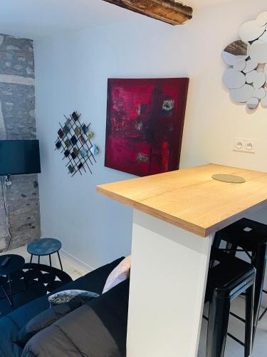 une cuisine avec un comptoir et une table avec des tabourets dans l'établissement Joli studio Centre historique, à Pau