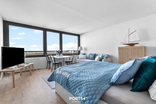 ein Schlafzimmer mit einem Bett und ein Wohnzimmer mit einem TV in der Unterkunft Waterfront 7601 Marina Wendtorf in Wendtorf
