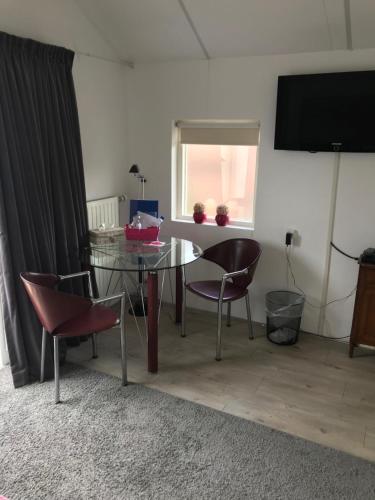 a dining room with a glass table and chairs at Villa 't Haasduin in Wijk aan Zee