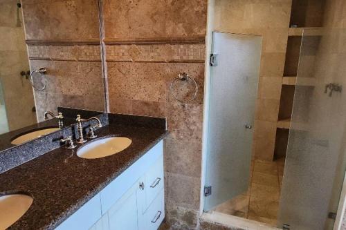 a bathroom with two sinks and a shower at Dream Penthouse Escazú in San Rafael