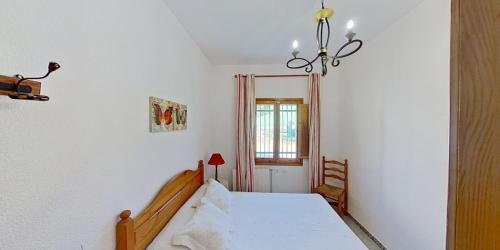 1 dormitorio con cama blanca y ventana en El Pincell en Valencia
