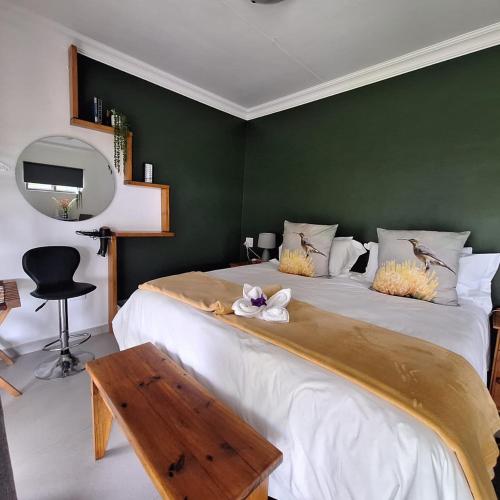a bedroom with two beds with a green wall at Paradise View Guesthouse in Graskop
