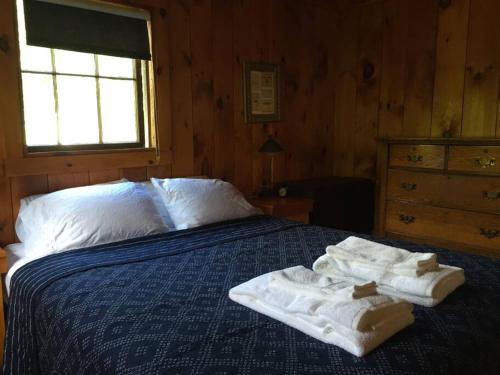 Dos toallas sentadas en una cama en un dormitorio en The Sugar House en East Dummerston