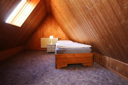 a bedroom with a bed in a wooden attic at Semi-detached house Nordseebrise Niebüll - DNS09100i-L in Niebüll