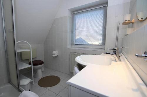 a white bathroom with a sink and a toilet at Semi-detached house Nordseebrise Niebüll - DNS09100i-L in Niebüll