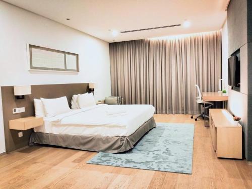 a bedroom with a bed and a desk and a television at 188 Suites klcc by Luxe suites in Kuala Lumpur