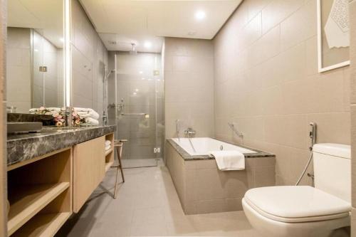 a bathroom with a toilet and a sink and a shower at 188 Suites klcc by Luxe suites in Kuala Lumpur