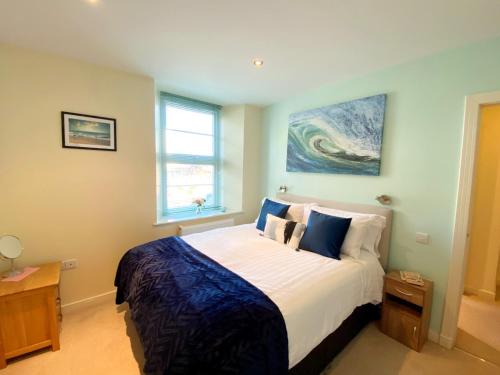 a bedroom with a bed and a painting on the wall at Sea View Apartment, 7 Ellington Court in Torquay