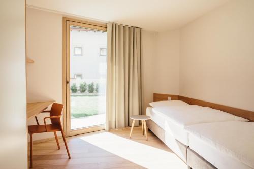 a bedroom with a bed and a desk and a window at Appartement Steinach in Schenna