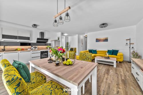 eine Küche und ein Wohnzimmer mit einem Tisch und gelben Stühlen in der Unterkunft Ferienwohnung Ostseeinsel Fehmarn in Fehmarn