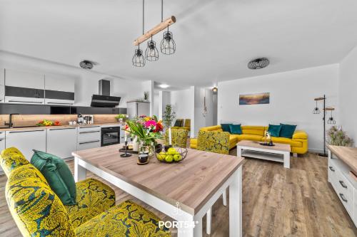 a kitchen and living room with a table and yellow chairs at Ferienwohnung Ostseeinsel Fehmarn in Fehmarn