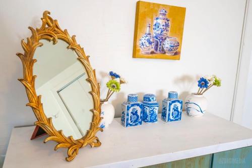 a mirror on a shelf with blue and white vases at Crow's Nest Crash-Pad in Homestead