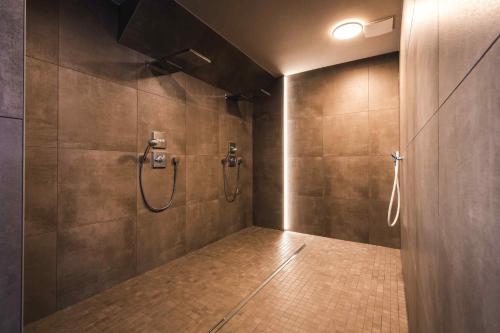 a bathroom with two shower heads on the wall at Ferienhäuser Baltic Lagoon Haus 14a in Fuhlendorf
