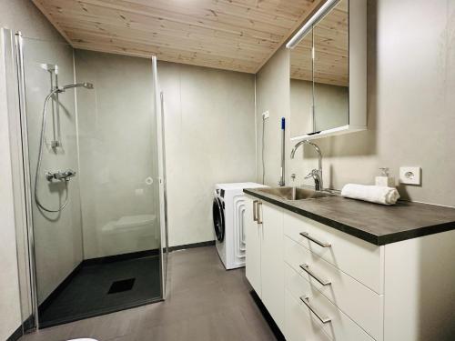 a small bathroom with a shower and a sink at Superior Ocean View Lofoten in Ballstad