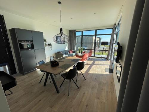 una cucina e un soggiorno con tavolo e sedie di Chalet Meeresblick Zweite Reihe Haus Nr 250 a Enkhuizen