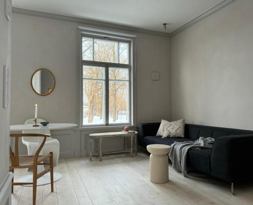 uma sala de estar com um sofá azul e uma mesa em Uniikki ja tunnelmallinen empireasunto Hämeenlinnan ydinkeskustassa em Hämeenlinna