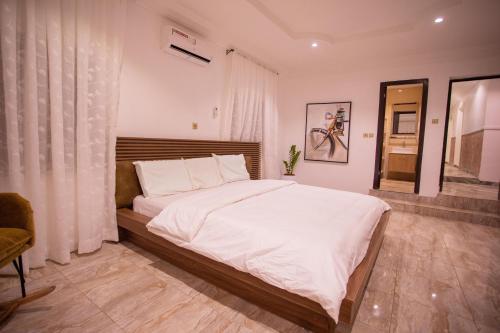 ein Schlafzimmer mit einem großen Bett mit weißer Bettwäsche in der Unterkunft Luxury 3 bed Apartmnt with Minimalist Aesthetic in Abuja