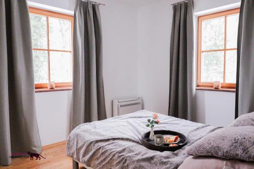a bedroom with gray curtains and a bed with a tray on it at Naturtalente Berghaus - Moonlakeview s in Innerschwand