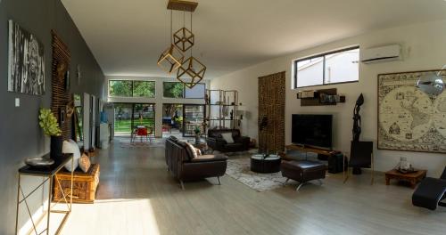 a living room with a couch and a tv at La Caduta Luxury Villa in Livingstone