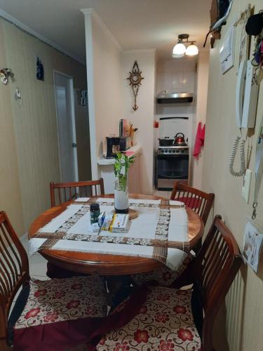 uma cozinha com uma mesa com quatro cadeiras e uma mesa em Comparto Depto. en La Cisterna ( hermoso y cómodo, cómo en casa) em Santiago
