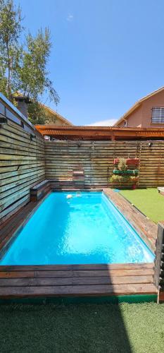 a swimming pool in a backyard with a retaining wall at Casa con piscina en San Bernardo in Santiago